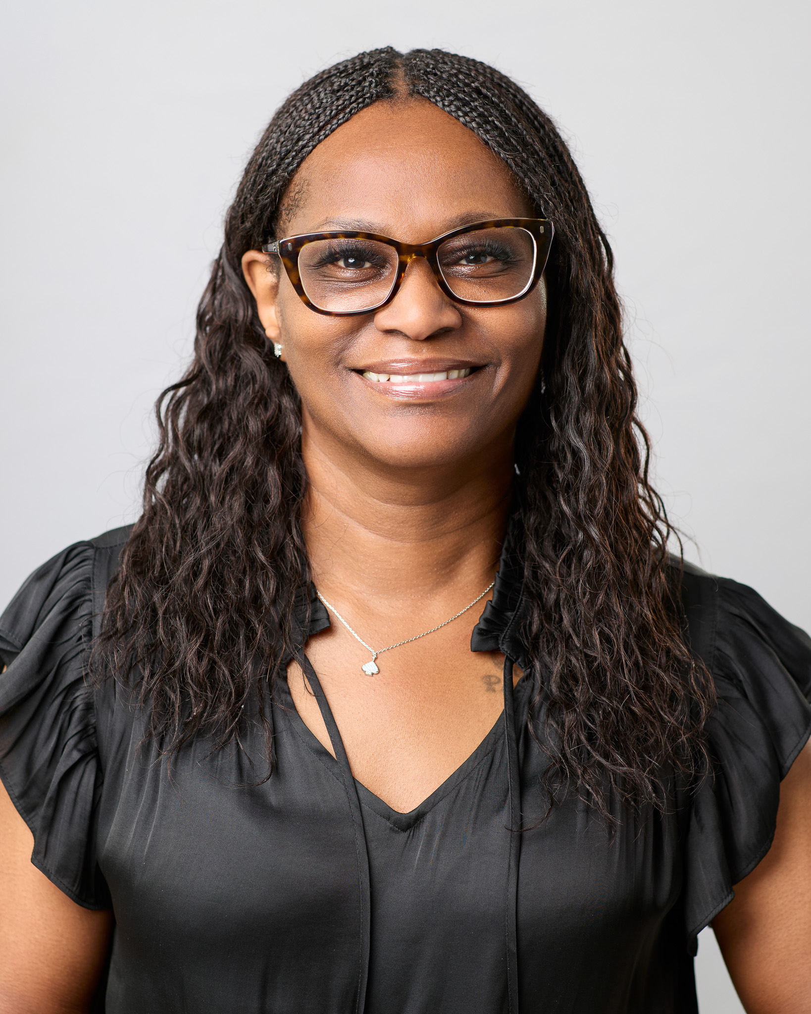 Headshot of a women in glasses wearing business professional.
