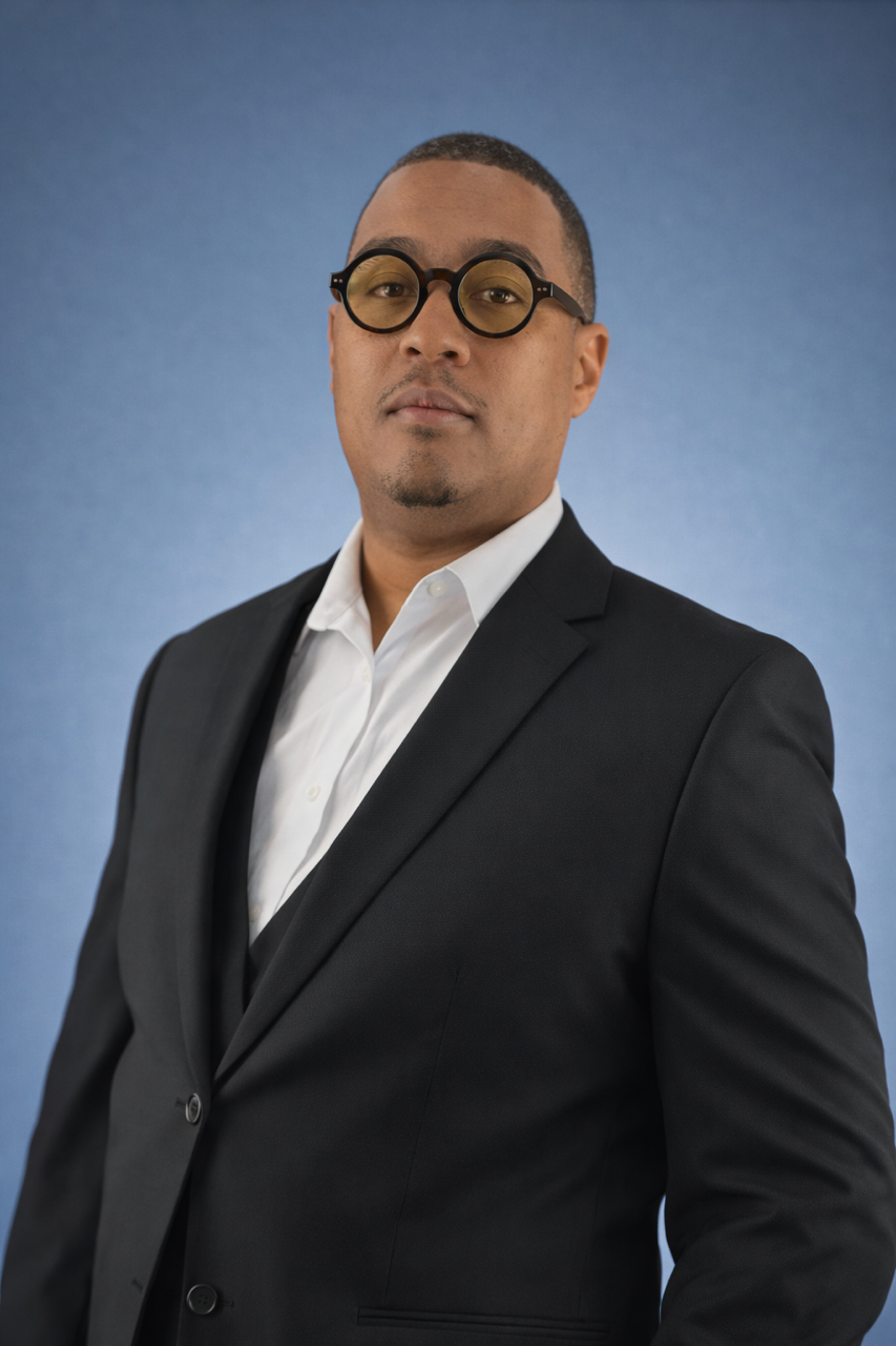 Headshot of a man in glasses wearing business professional.